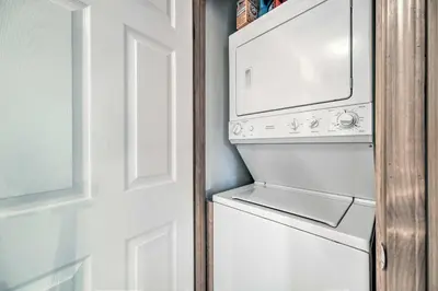 a white washer and dryer next to a door at 4 Mi to Big Tree State Park Serene Cabin with Deck in Arnold