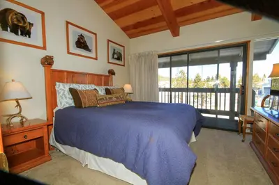 a bedroom with a blue bed and a balcony at Sierra Park Villas 23 in Mammoth Lakes