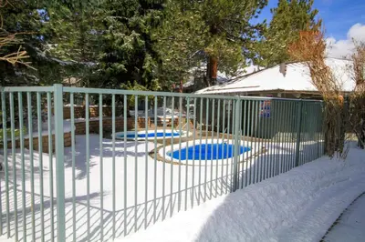 a fence in the snow with two dogs in it at Sierra Park Villas 23 in Mammoth Lakes