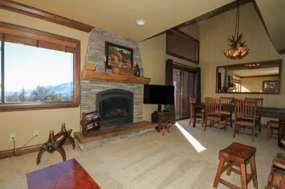 a living room with a fireplace and a dining room at Sierra Park Villas #67 in Mammoth Lakes