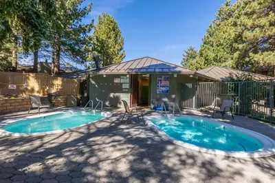 a swimming pool in a yard with chairs and a fence at Sierra Park Villas 04 in Mammoth Lakes