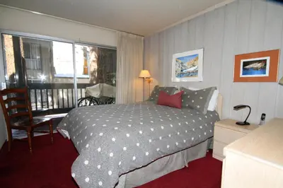 a hotel room with a bed and a balcony at SIerra Park Villas #06 in Mammoth Lakes