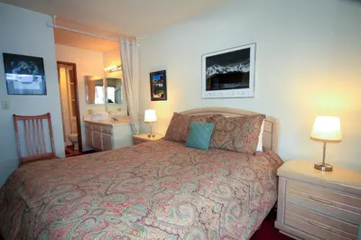 a bedroom with a large bed and a bathroom at SIerra Park Villas #06 in Mammoth Lakes