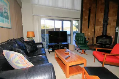 a living room with a black leather couch and a tv at Sierra Park Villas 24 in Mammoth Lakes