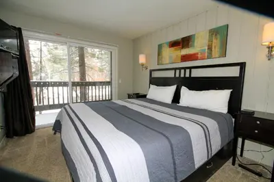 a bedroom with a large bed and a balcony at Sierra Park Villas 03 in Mammoth Lakes