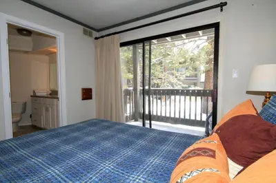 a bedroom with a bed and a sliding glass door at Sierra Park Villas 93 in Mammoth Lakes