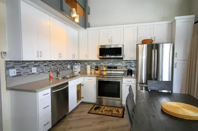 a kitchen with white cabinets and a stainless steel refrigerator at Sierra Park Villas 93 in Mammoth Lakes