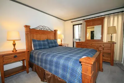 a bedroom with a bed and a dresser and a mirror at Sierra Park Villas 93 in Mammoth Lakes