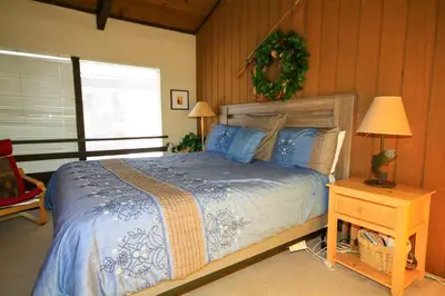 a bedroom with a bed and a table with a lamp at Sierra Park Villas 16 in Mammoth Lakes