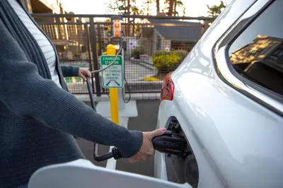 a person fueling a car at a parking meter at Comfy 2-Bedroom Home with Pool in Mammoth Lakes