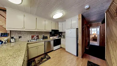 a kitchen with white cabinets and a white refrigerator at Comfy 2-Bedroom Home with Pool in Mammoth Lakes