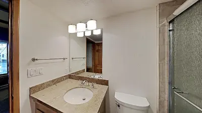 a bathroom with a sink and a toilet and a mirror at Comfortable 2 BR Loft Slope View Condo! in Mammoth Lakes