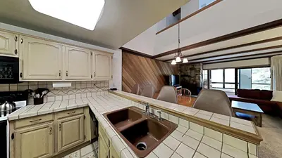 a kitchen with a sink and a living room at Comfortable 2 BR Loft Slope View Condo! in Mammoth Lakes