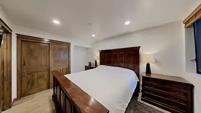 a bedroom with a bed and a wooden dresser at Remodeled 2 Bedroom Condo with Amazing Views! in Mammoth Lakes