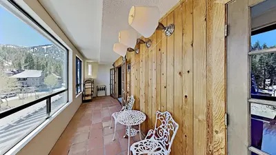 a balcony with a table and chairs and windows at Beautiful 2 Bedroom Condo with Mountain View! in Mammoth Lakes
