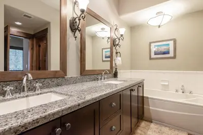 a bathroom with two sinks and a bath tub and a tubermott at Woodwinds 22 in Mammoth Lakes