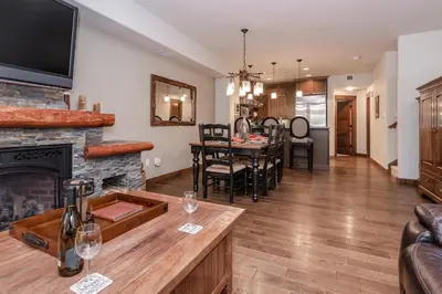 a living room with a fireplace and a dining room at Woodwinds 22 in Mammoth Lakes