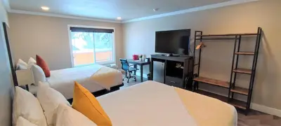 a hotel room with two beds and a flat screen tv at The Elet Hotel in South Lake Tahoe
