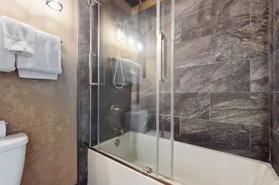 a bathroom with a shower with a tub and a toilet at North Lake Loft in Kings Beach