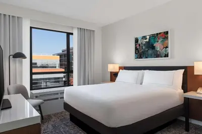 a hotel room with a bed and a desk and a window at Tapestry By Hilton The Fort Sutter Hotel Sacramento, Ca in Sacramento