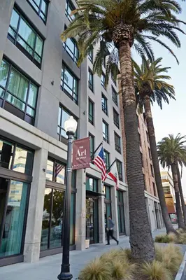 a street sign in front of a building with palm trees at Tapestry By Hilton The Fort Sutter Hotel Sacramento, Ca in Sacramento