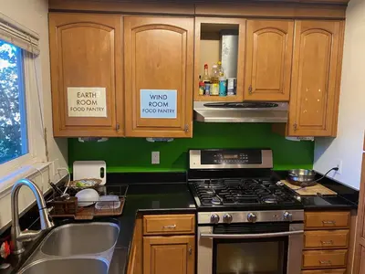 a kitchen with wooden cabinets and a stove top oven at WHOLE Family - Rosemont in Sacramento
