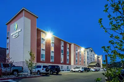 a hotel with cars parked in a parking lot at WoodSpring Suites Reno Sparks in Sparks