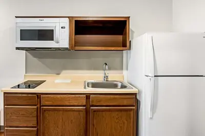 a kitchen with a sink and a white refrigerator at WoodSpring Suites Reno Sparks in Sparks