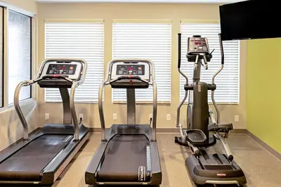 a gym with three tread machines in a room at WoodSpring Suites Reno Sparks in Sparks