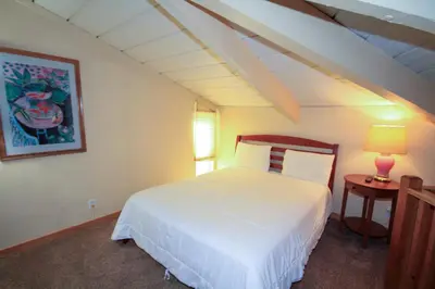 a bedroom with a white bed and a table with a lamp at Sierra Park Villas 20 in Mammoth Lakes