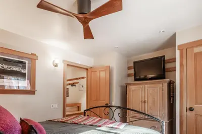 a bedroom with a ceiling fan and a tv at Northstar - Ski View Condo in Truckee