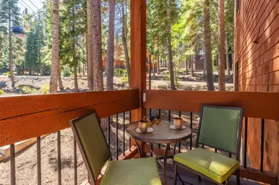 a balcony with a table and chairs and trees at Northstar - Ski View Condo in Truckee