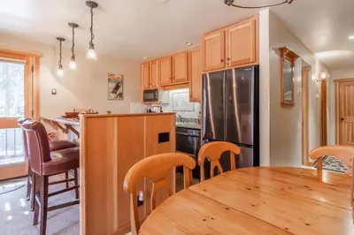 a kitchen with a wooden table and a refrigerator at Northstar - Ski View Condo in Truckee