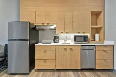 a kitchen with a stainless steel refrigerator and wooden cabinets at TownePlace Suites by Marriott Sacramento Elk Grove in Elk Grove