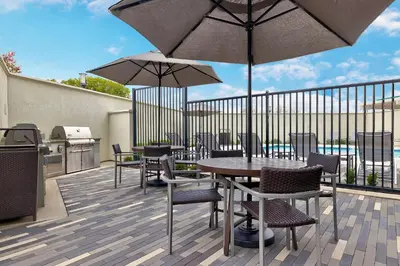 a patio with a table and chairs and umbrellas at TownePlace Suites by Marriott Sacramento Elk Grove in Elk Grove
