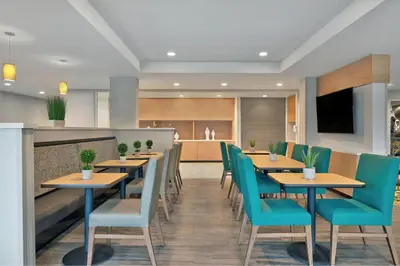 a restaurant with wooden tables and blue chairs at TownePlace Suites by Marriott Sacramento Elk Grove in Elk Grove