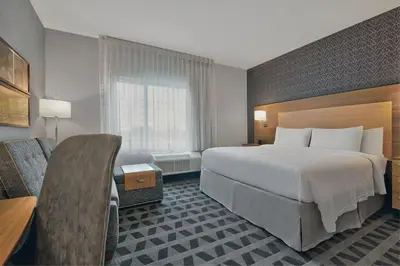 a hotel room with a bed and a chair at TownePlace Suites by Marriott Sacramento Elk Grove in Elk Grove