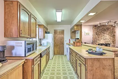a large kitchen with wooden cabinets and appliances at Home with Serene Deck in Twain Harte! in Twain Harte