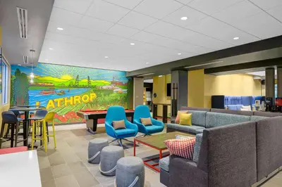 a waiting room with a couch and chairs and a table at Tru By Hilton Lathrop in Lathrop