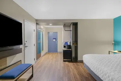 a hotel room with a bed and a flat screen tv at Tru By Hilton Lathrop in Lathrop