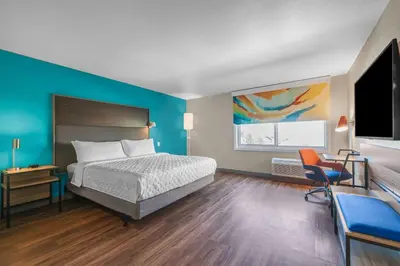 a bedroom with a bed and a desk and a tv at Tru By Hilton Lathrop in Lathrop