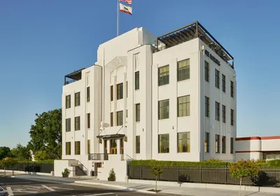 a white building with a flag on top of it at The Darling in Visalia