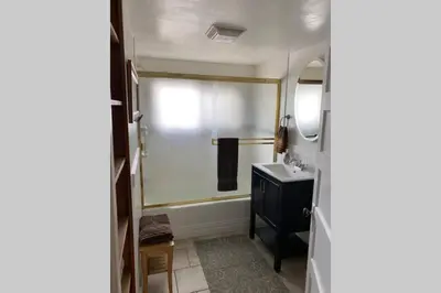 a bathroom with a shower and a sink and a mirror at Vans Yosemite Garden Cottage in Groveland