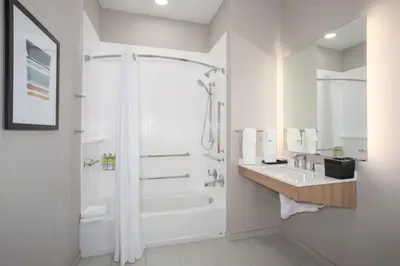 a white bathroom with a shower and a sink at Staybridge Suites - Carson City - Tahoe Area by IHG in Carson City
