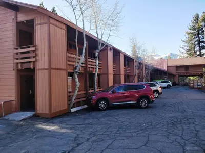 a red suv parked in front of a building at Ventura Grand Inn in Mammoth Lakes