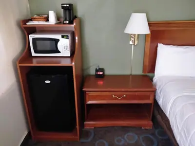 a hotel room with a microwave and a bed at Ventura Grand Inn in Mammoth Lakes