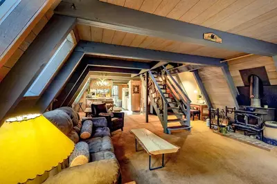 a living room with a couch and a wooden ceiling at Under The Trees in Camp Connell