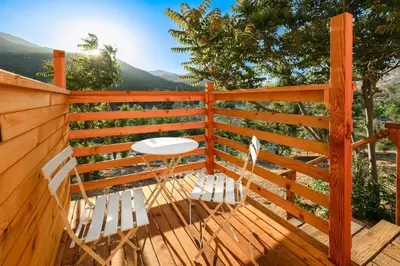 a wooden deck with two chairs and a table at SoCal Camping in Kernville