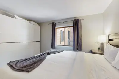 a bedroom with a white bed and a window at Cozy Coyote Fork Condo in Truckee