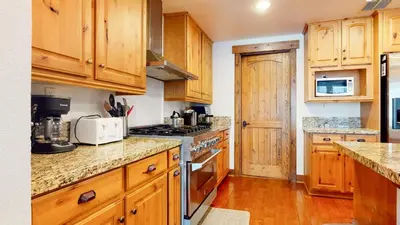 a kitchen with wooden cabinets and a stove top oven at Snowcreek The Lodges #1130 condo in Mammoth Lakes